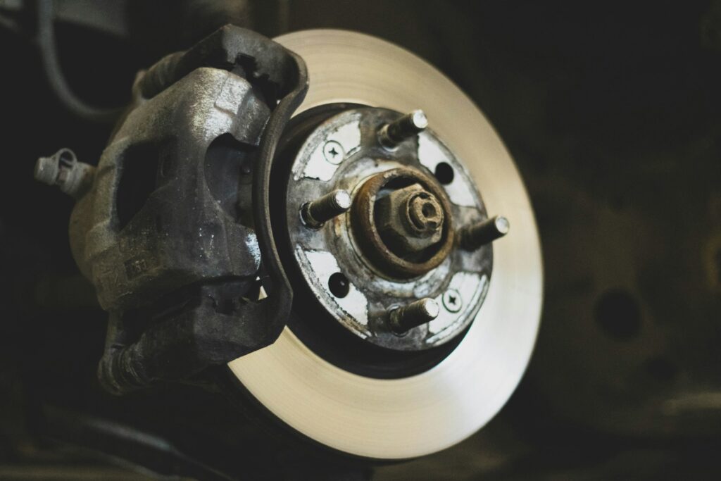 Close-up of a car disc brake rotor and caliper, the parts most often behind a car shaking when braking