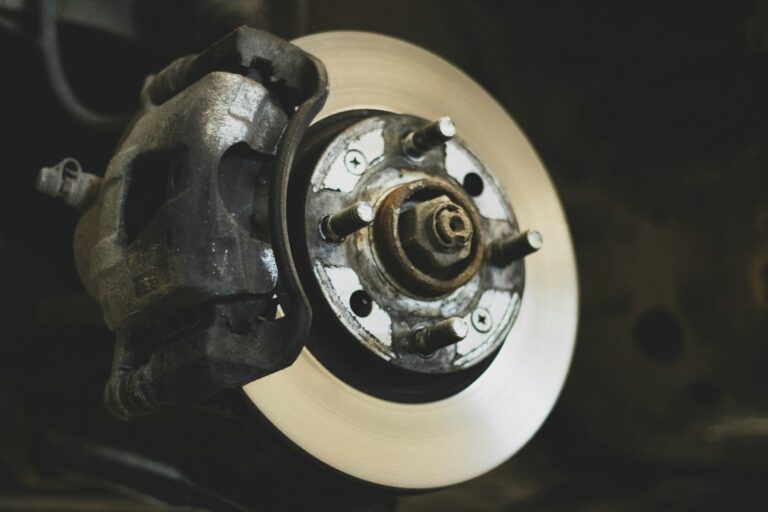 Close-up of a car disc brake rotor and caliper, the parts most often behind a car shaking when braking